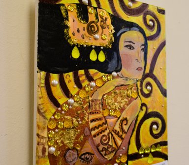 Obraz w tonacji żółci i złota oraz beżu, brązu i czerni. Czarnowłosa kobieta patrząca w prawo. Jej ciało pokrywają ornamenty oraz perły i złote elementy, które autor przykleił do płótna.