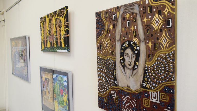 Widzimy rzut na cztery obrazy widziane pod kątem. Najbliżej widza jest popiersie kobiety, która unosząc dłonie, splata palce razem. Jej oczy są zamknięte, we włosach przeplatają się kwiatuszki. Tło rozmigotane, zawiera spiralne wzory oraz różnego rodzaju 