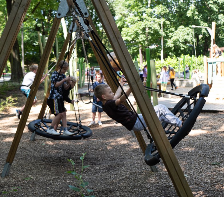 Zdjęcia dzieci podczas zabawy na placu zabaw