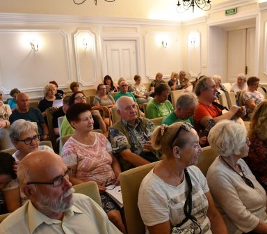 Widok na tłum siedzący na krzesłach w sali widowiskowej.