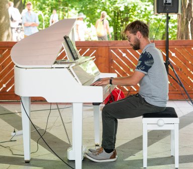 Pianista podczas gry na białym fortepianie