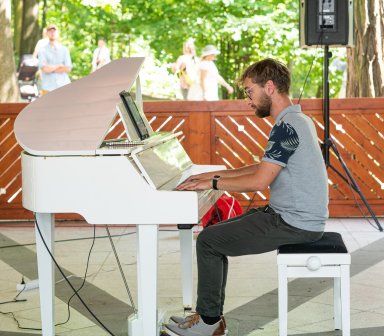 Pianista podczas gry na białym fortepianie