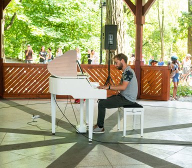 Pianista podczas gry na białym fortepianie