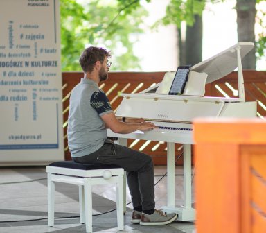 Pianista podczas gry na białym fortepianie