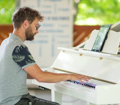 Pianista podczas gry na białym fortepianie