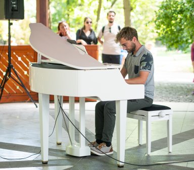 Pianista podczas gry na białym fortepianie