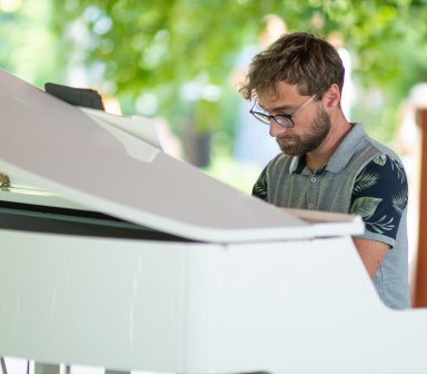 Pianista podczas gry na białym fortepianie