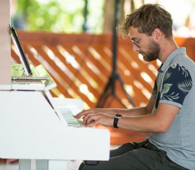 Pianista podczas gry na białym fortepianie