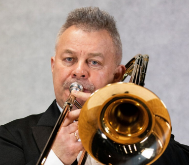 Mężczyzna gra na instrumencie dętym.